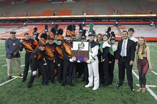 Marching band with plaque on field