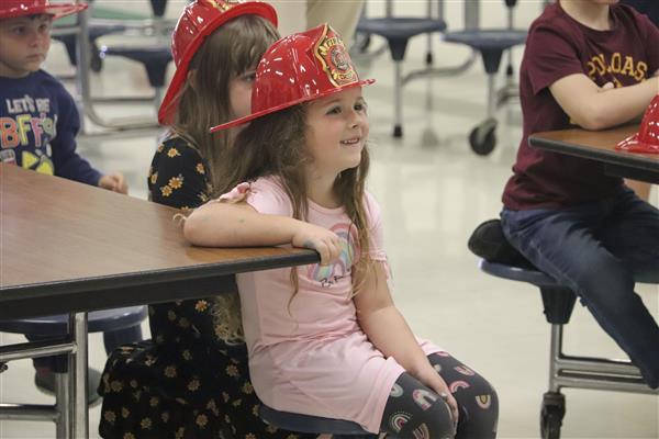 Student at Fire Safety Day wearing a fireman toy hat.